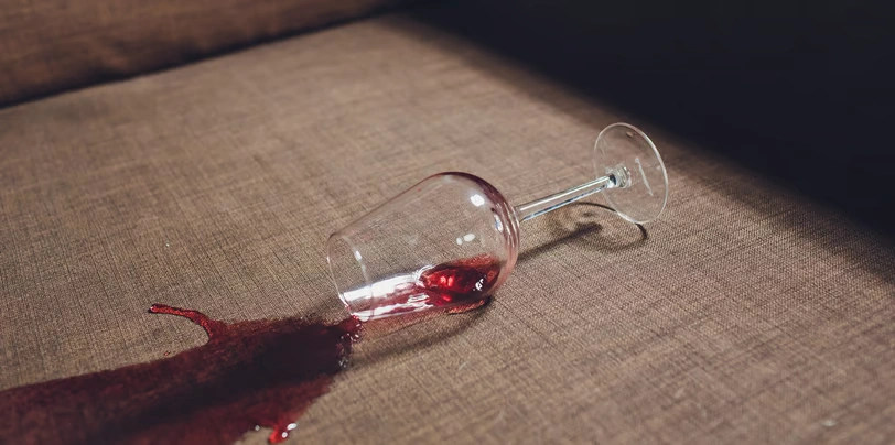 Taça de vinho derramada sobre sofá